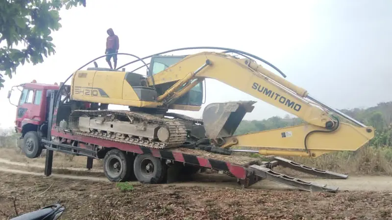 La pelleteuse arrive sur un camion plateau