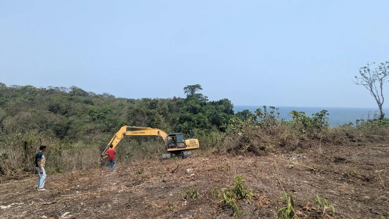 Une pelleteuse sur le terrain défriché de Kabisu, l’océan en arrière-plan