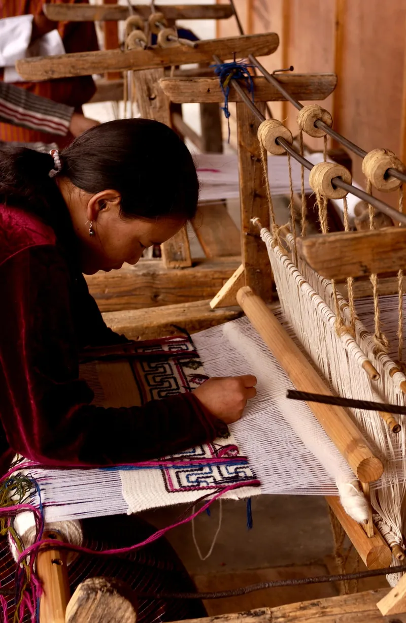 A Sumbanese woman working on a traditional loom to create ikat textiles.
