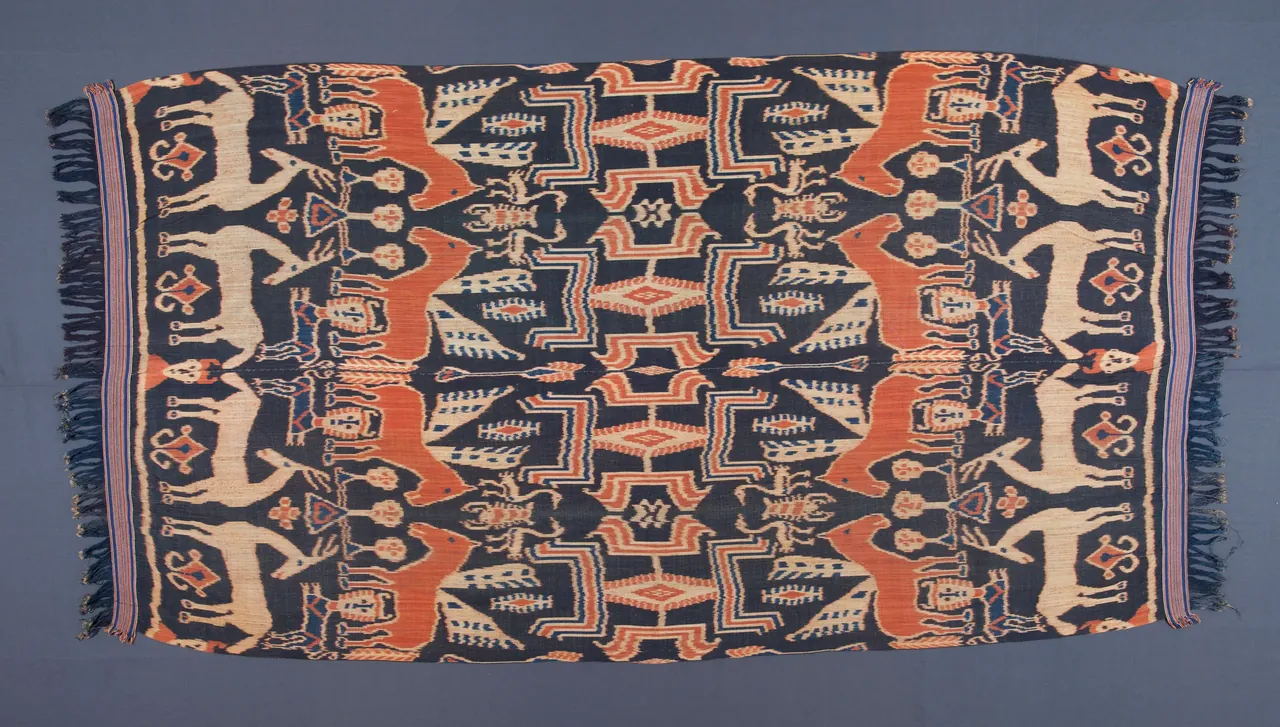 Traditional Sumba hinggi cloth with complex ancestral motifs and symmetrical layout.